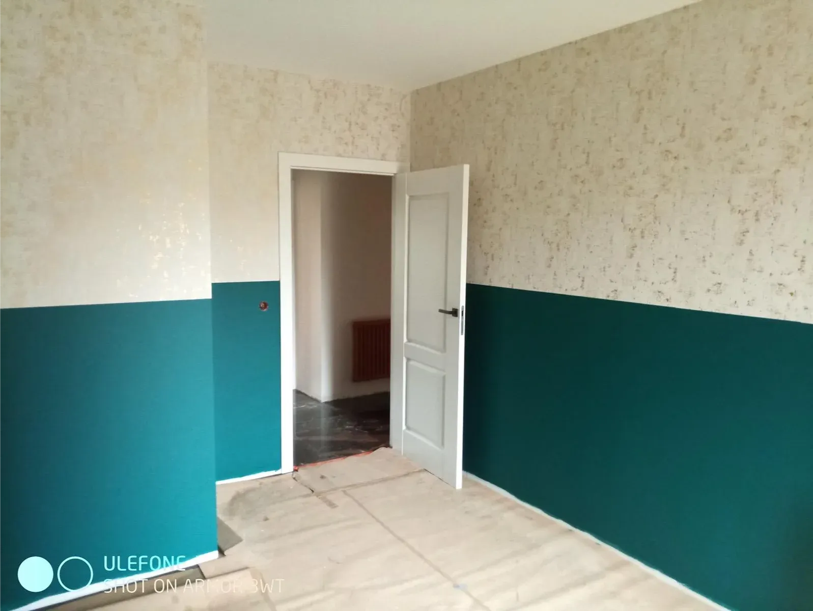 Pokój z dolną częścią ścian pomalowaną na turkusowo